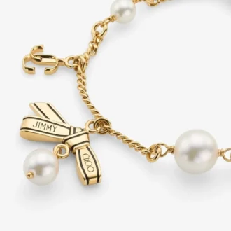 Armband met meerdere bedeltjes en linten  Gouden metalen bedelarmband met linten en parels