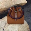 Bon Bon Tan suède bucket bag met kralensluiting en schildpadkleurig handvat Bon Bon Tan suède bucket bag met kralensluiting en schildpadkleurig handvat