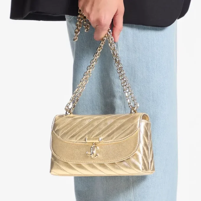 Curve Cross Body Small Goudkleurige gewatteerde metallic nappalederen crossbodytas Curve Cross Body Small Goudkleurige gewatteerde metallic nappalederen crossbodytas