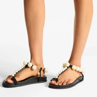 Miro platte zwarte suède sandalen met parelmoeren bolletjes