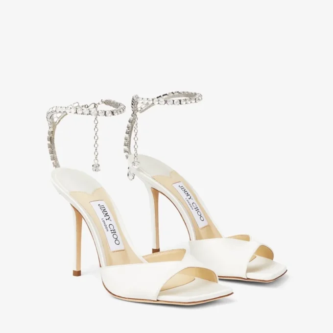 Saeda-sandaal 100 Ivoorkleurige satijnen sandalen met kristallen versiering Saeda-sandaal 100 Ivoorkleurige satijnen sandalen met kristallen versiering