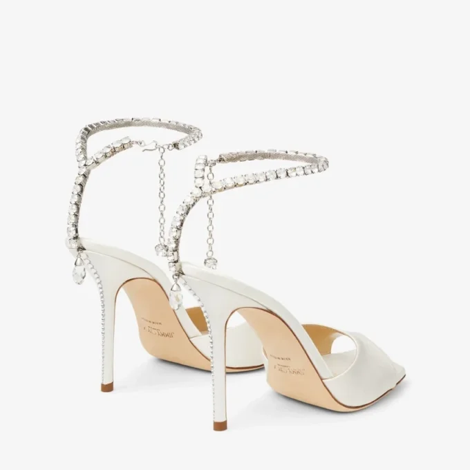 Saeda-sandaal 100 Ivoorkleurige satijnen sandalen met kristallen versiering Saeda-sandaal 100 Ivoorkleurige satijnen sandalen met kristallen versiering